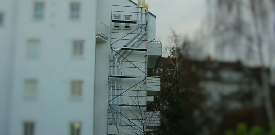 PVC Abluftleitung an Gebäudefassade, Abluftrohre in Fassadenfarbe lackiert